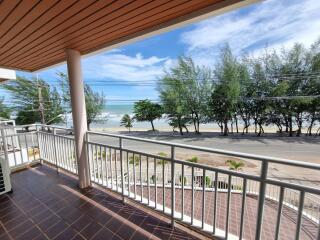 Spacious balcony with ocean view and lush trees