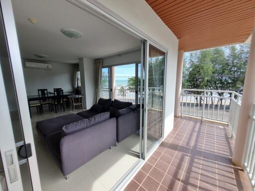 Spacious living room with open balcony doors leading to a seaside view