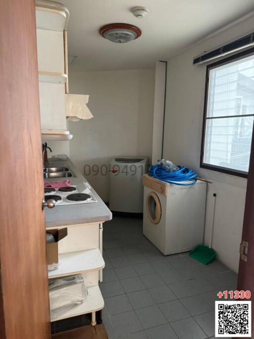 Compact kitchen with white cabinetry and appliances