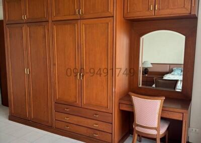 Spacious bedroom with wooden wardrobe and dressing table