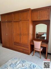 Spacious bedroom with wooden wardrobe and dressing table