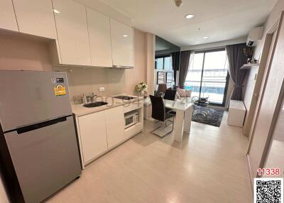 Modern open-concept kitchen with adjacent living space featuring large windows and contemporary furniture