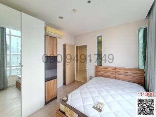 Spacious bedroom with large windows and wooden furniture