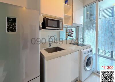 Modern kitchen with white appliances and a window