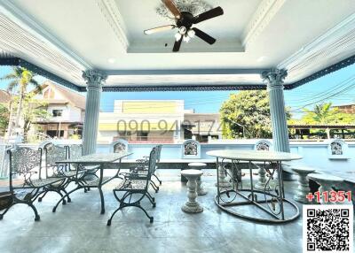 Spacious covered patio area with seating and ceiling fan