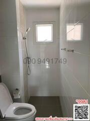 Modern bathroom with white fixtures and tiled walls