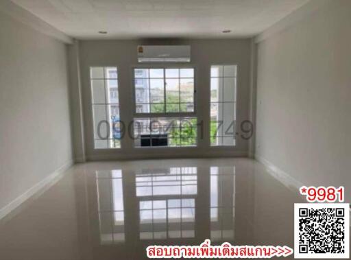 Spacious and well-lit living room with reflective tile flooring and a large window