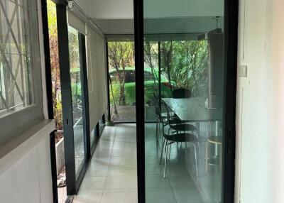 View through sliding glass doors onto a covered patio area with outdoor furniture
