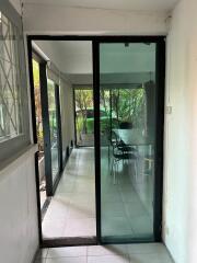 View through sliding glass doors onto a covered patio area with outdoor furniture