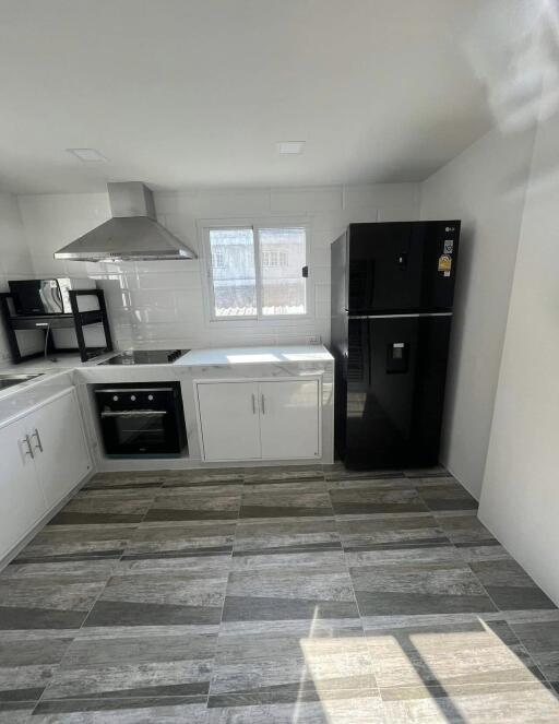 Modern kitchen with stainless steel appliances and tile flooring