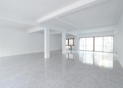 Spacious and bright unfurnished interior of an empty building with glossy tiled floors and multiple columns