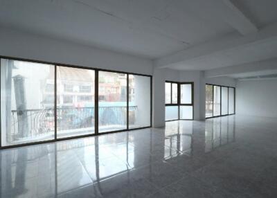 Spacious and well-lit empty room with large windows and tiled flooring