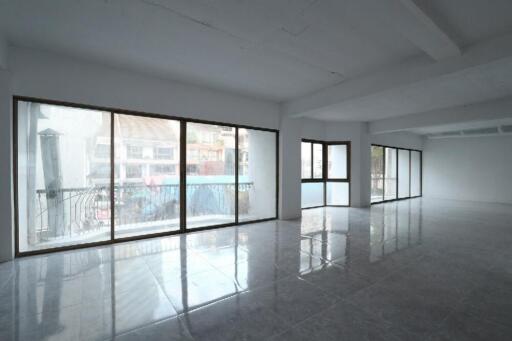 Spacious and well-lit empty room with large windows and tiled flooring