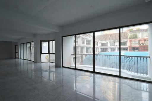 Spacious unfurnished room with large windows overlooking a swimming pool