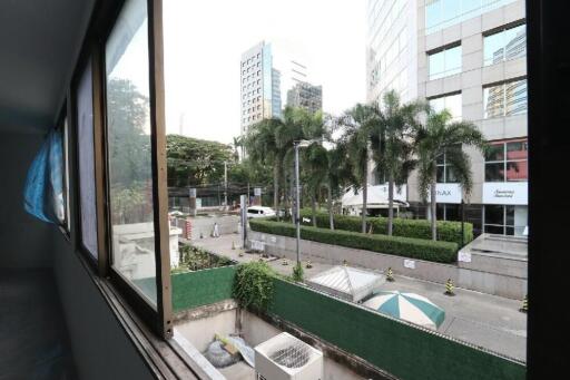 Urban view from a window overlooking a city street with trees and buildings