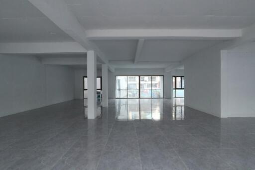 Spacious unfurnished interior of a modern building with high ceilings and large windows