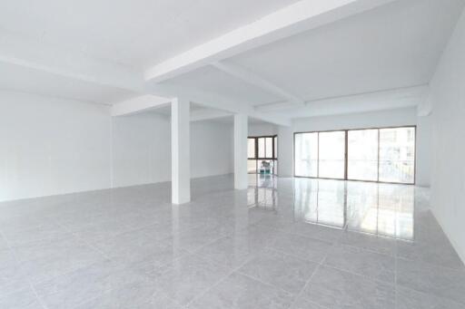 Spacious empty interior of a modern building with glossy tiled floors and large windows