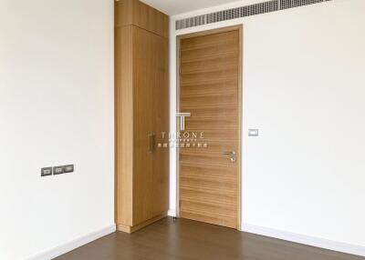 Modern bedroom with wooden door and large closet