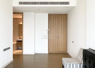 Empty living room with wooden closet and striped armless chair