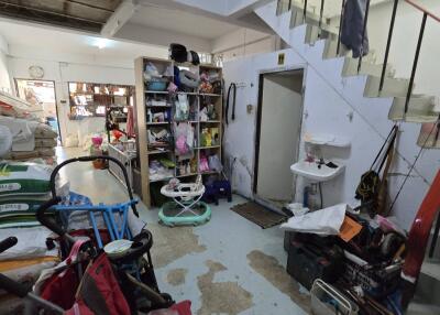 Cluttered storage area with staircase and various items