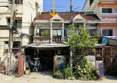 Traditional urban house with visible wear and lush greenery