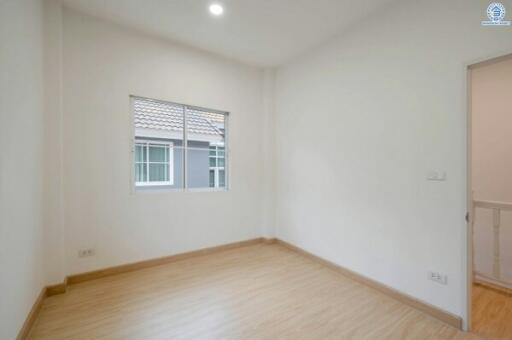 Bright and empty bedroom with hardwood floors and a large window