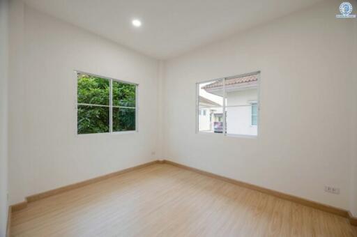 Empty bedroom with large windows and natural light