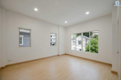 Spacious and well-lit empty living room with hardwood floors