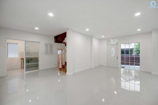 Bright and spacious living room with shiny tiled floor and stairs leading to the upper level