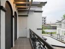 Cozy balcony with ceramic tile flooring and iron railing overlooking neighborhood