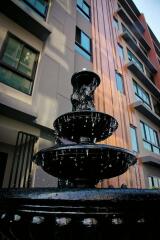 Elegant fountain in front of modern building facade with windows