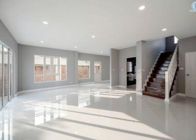 Spacious and brightly lit living room with polished floor and staircase