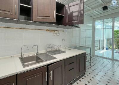 Modern kitchen with stainless steel sink, dark wood cabinets, and patterned floor tiles