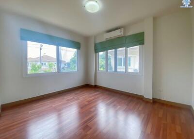 Spacious unfurnished bedroom with hardwood floors and natural light