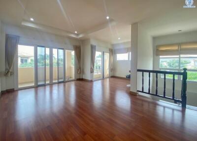 Spacious and well-lit living room with hardwood floors and large windows