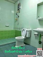 Compact bathroom with green tiles and essential fixtures
