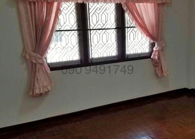Empty bedroom with bare floor and pink curtains