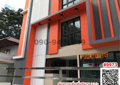 Modern building exterior with orange accents and large windows