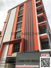 Modern multi-story residential building with vibrant orange and white facade