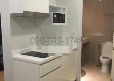 Small kitchenette with modern appliances and access to bathroom