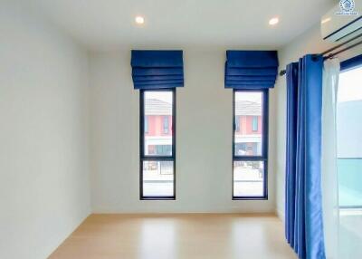 Bright and minimalist bedroom with large windows and hardwood floors