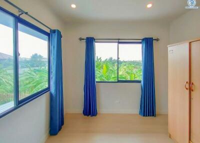 Bright bedroom with a view of greenery and blue curtains