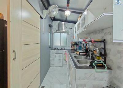 Compact modern kitchen with stainless steel sink and ample storage cabinets