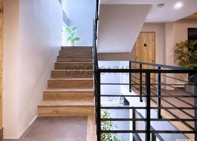 Modern staircase with wooden steps and metal railing in a residential house