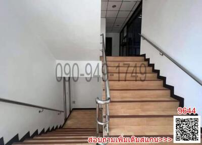 Modern staircase with stainless steel handrail leading to upper floor