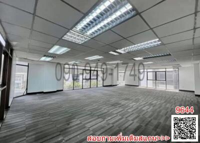 Spacious commercial office space with carpet flooring and ample natural lighting