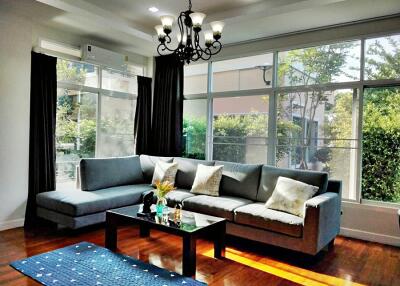 Spacious and well-lit living room with a comfortable seating area and large windows