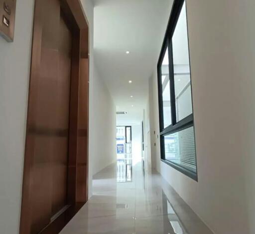 Bright and spacious hallway with large windows and tiled flooring