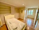 Cozy bedroom with built-in shelves and hardwood floor