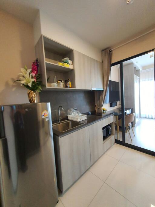 Modern compact kitchen with stainless steel appliances and a bright atmosphere